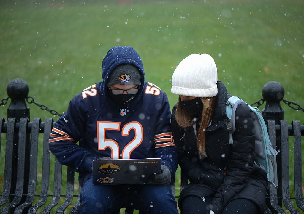Justin Craft and Allison Craft attend a Zoom class while snow falls around them